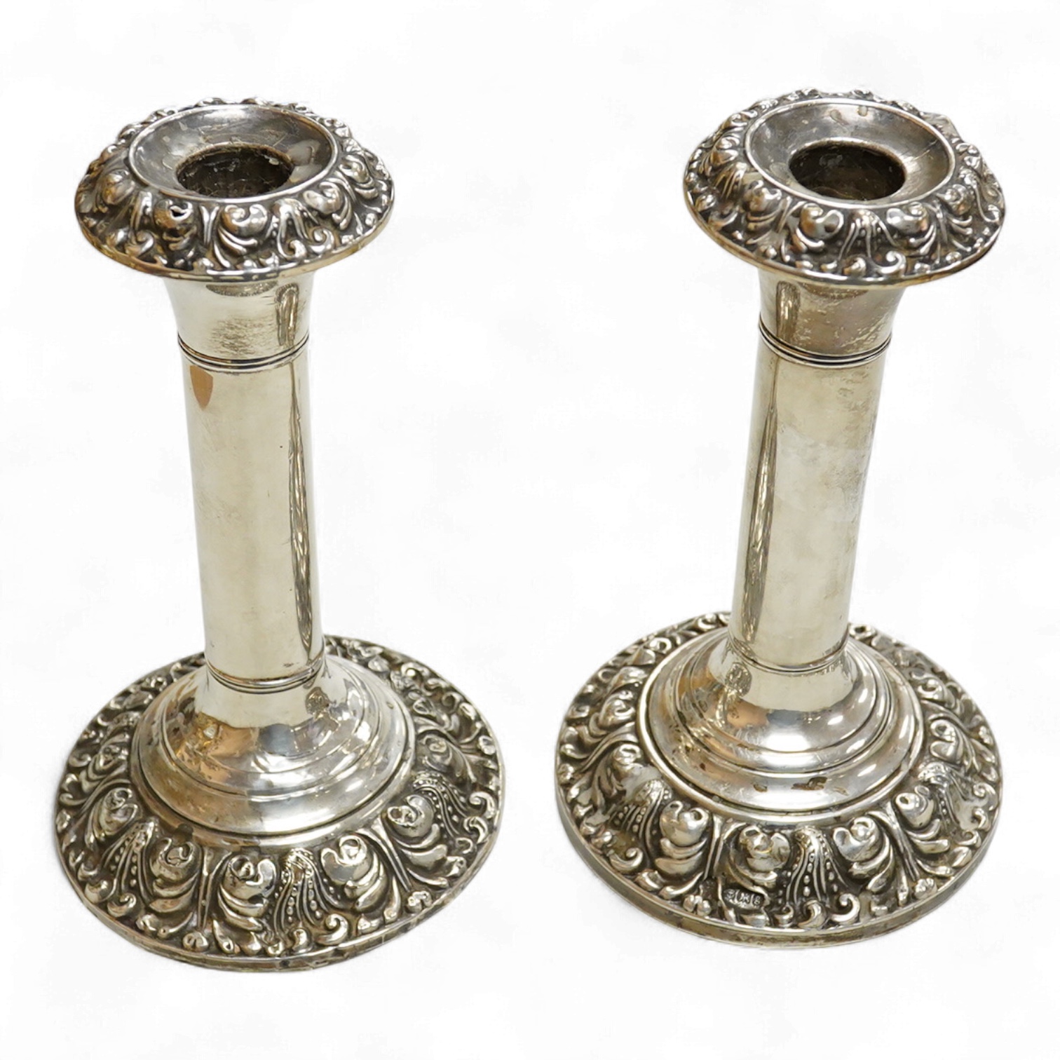A pair of Edwardian silver mounted candlesticks, with embossed scroll bases, Martin, Hall & Co, Birmingham, 1906, height 19cm, weighted, (a.f.).